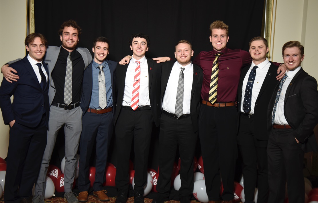 Eight brothers posing together in formalwear